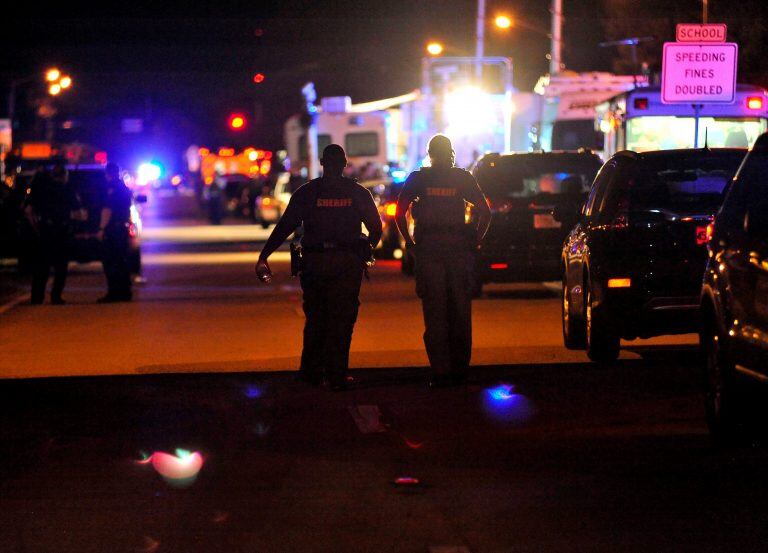 Police vehicles block the road to Marjory Stoneman Douglas High School in Parkland, Florida, following a shooting that killed 17 people on February 14, 2018 in Parkland, Florida. 
A former student armed with an AR-15 rifle opened fire at a Florida high school, killing at least 17 people, officials said, in a harrowing shooting spree that saw terrified students hiding in closets and under desks as they texted for help. Broward County Sheriff Scott Israel identified the gunman as Nikolas Cruz, 19, a former student at Marjory Stoneman Douglas High School in Parkland who had been expelled for "disciplinary reasons."
 / AFP PHOTO / Gaston De Cardenas