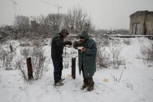 Migrants eat free food during a snowfall outside a derelict customs warehouse in Belgrade, Serbia January 9, 2017. REUTERS/Marko Djurica