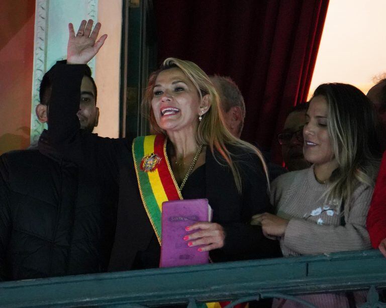 La senadora opositora Jeanine Áñez, con una Biblia en la mano, saluda a sus simpatizantes tras autoproclamarse presidenta interina de Bolivia tras una sesión parlamentaria donde no hubo quorum. Crédito: EFE/STRINGER.