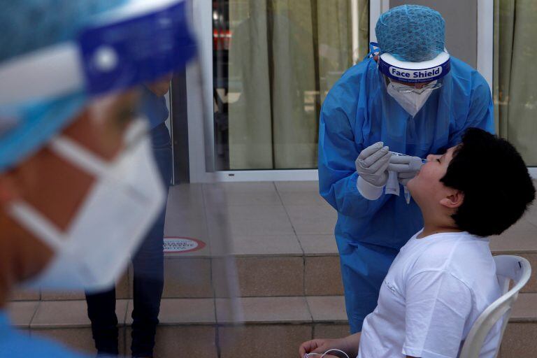 Medical officials conduct coronavirus tests, at Engomi B primary school in capital Nicosia, Cyprus, Thursday, May 21, 2020. Cyprus took a major step toward a return to normality on Thursday when most restrictions of a two month-long stay-at-home order were lifted, allowing primary school kids to return to classes and hair salons and outdoor cafeterias to re-open. (AP Photo/Petros Karadjias)