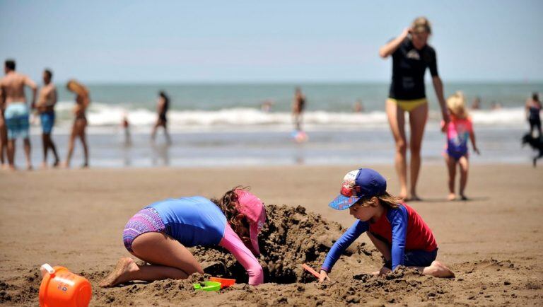 Niños jugando en la playa con remeras UV. (Foto: Maxi Failla/Clarín)