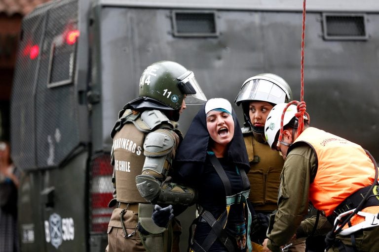 Jóvenes se enfrentan a carabineros mientras protestan por la llegada del papa Francisco.