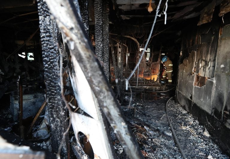 Bomberos apagan los restos del fuego en un cuarto de hospital afectado durante un incendio en Miryang (Corea del Sur)