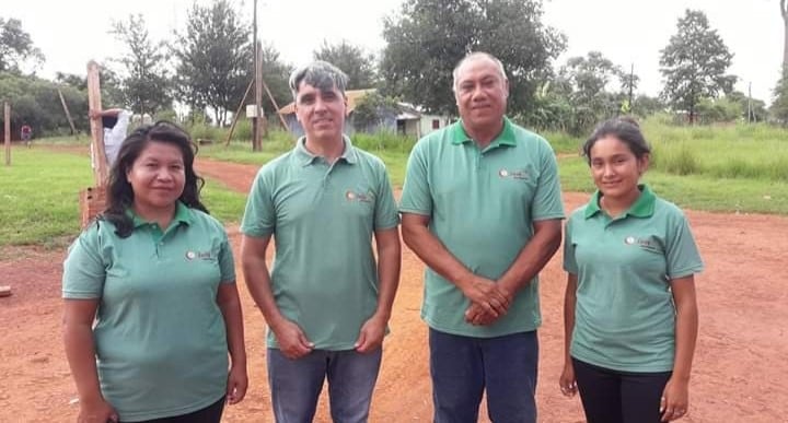 La reportera Gabriela Duarte y la camarógrafa Graciela Moreira, rodean a Basilio Salas y el cacique Silvino Moreira, vistiendo sus remeras de Jasy TV de la aldea Fortín Mbororé (Telenorte de Puerto Libertad).