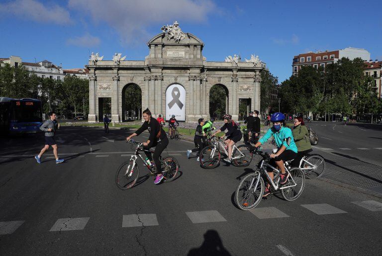 Vista de la Puerta de Alcalá con un crespón junto a la gente haciendo deporte, en Madrid este domingo durante el séptimo día de la fase 0 de la desescalada en la comunidad. (Foto: EFE/ JuanJo Martín)