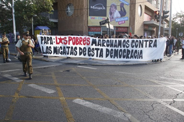 BH03. SANTIAGO (CHILE), 16/01/2018.- Jóvenes protestan por la llegada del papa Francisco hoy, martes 16 de enero de 2018, por las calles de Santiago (Chile). La policía disolvió hoy en Santiago la "Marcha de los Pobres", convocada por varias organizaciones sociales en protesta contra la visita del papa Francisco a Chile, según informaron fuentes oficiales. El papa realizará una visita de tres días en Chile y posteriormente se trasladará a Perú. EFE/BENJAMIN HERNANDEZ