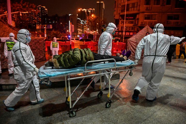 Un paciente en la zona en Wuhan, atendido por la Cruz Roja. (Foto:RETAMAL/AFP)