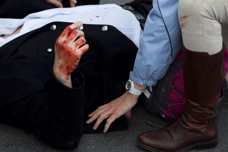 An injured man is assisted after an attack on Westminster Bridge in London, Britain March 22, 2017.  REUTERS/Toby Melville