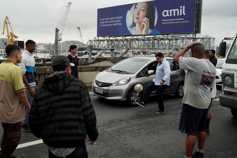 Los conductores bajaron de sus vehículos y jugaron a la pelota sobre el puente bloqueado por el secuestro (AP)