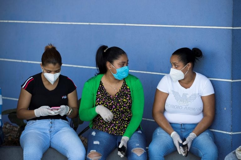 Mujeres con mascarillas esperan antecedentes sobre sus familiares afuera del hospital Moscoso Puello, este viernes en Santo Domingo (República Dominicana) (Foto: EFE/ Orlando Barría)