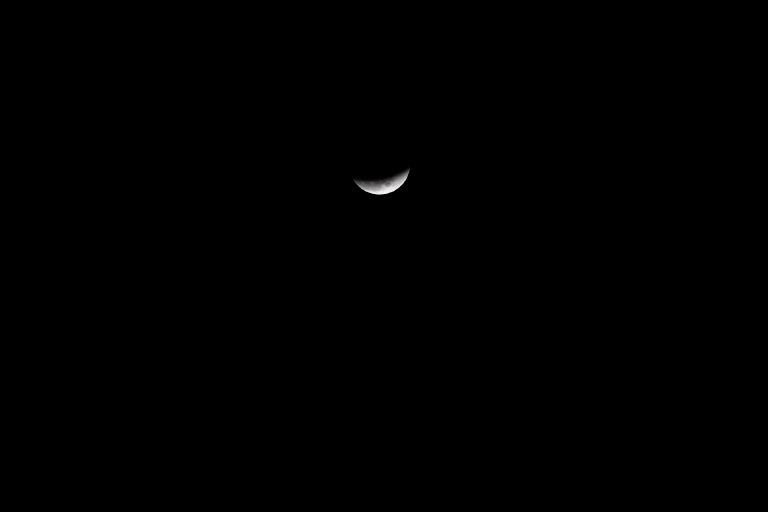 TOPSHOT - The moon is seen during a lunar eclipse, referred to as the "super blue blood moon", in New Delhi on January 31, 2018.
Skywatchers were hoping for a rare lunar eclipse that combines three unusual events -- a blue moon, a super moon and a total eclipse -- which was to make for a large crimson moon viewable in many corners of the globe. / AFP PHOTO / SAJJAD HUSSAIN