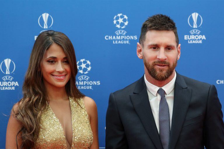 Antonela Roccuzzo junto Messi en el sorteo de la Champions League. (Photo by Valery HACHE / AFP)