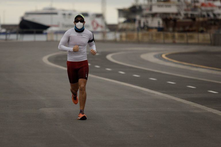 Un vecino, protegido con tapaboca, practica deporte por la capital tinerfeña este sábado tal y como ha permitido el Gobierno central para aliviar el confinamiento por el Covid-19. (Foto: EFE/Ramón de la Rocha)