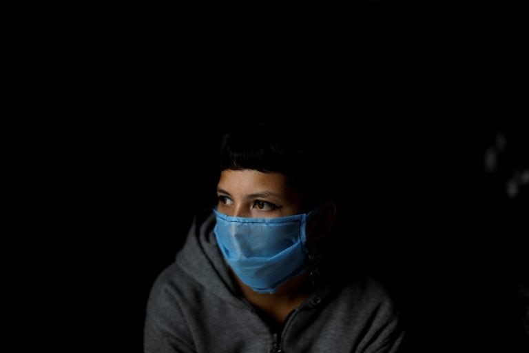 Volunteer Laura Da Costa, who helps prepare food, wears a protective face mask at a soup kitchen on the outskirts in Buenos Aires outskirts, Argentina, Wednesday, March 25, 2020. As a result of the new coronavirus pandemic, people are no longer allowed to eat at soup kitchen locations, but instead are asked to take the free meals to their homes in a plastic container. (AP Photo/Natacha Pisarenko)