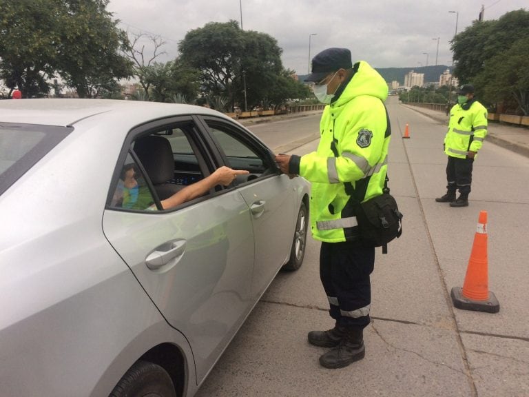 Efectivos policiales realizan controles vehiculares en calles y puentes de Jujuy, solicitando los permisos de circulación.