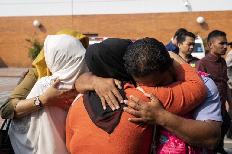 Los familiares de la víctima se reconfortan entre sí, esperando noticias