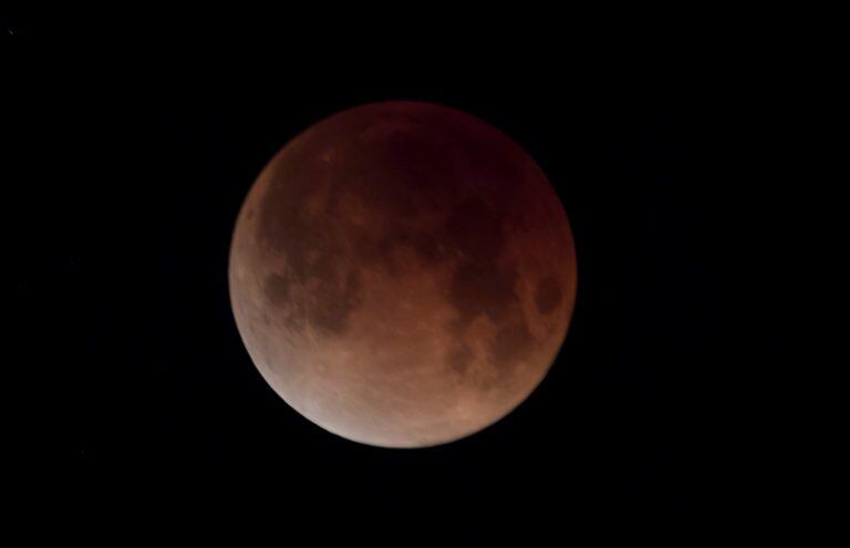 The eclipsing blood moon is shown in the early morning sky over North Vancouver, British Columbia, Canada,  Wednesday, Jan. 31, 2018.  It's the first time in 35 years a blue moon has synced up with a supermoon and a total lunar eclipse, or blood moon because of its red hue. Hawaii and Alaska had the best seats, along with the Canadian Yukon, Australia and Asia. The western U.S. also had good viewing, along with Russia. (Jonathan Hayward/The Canadian Press via AP)