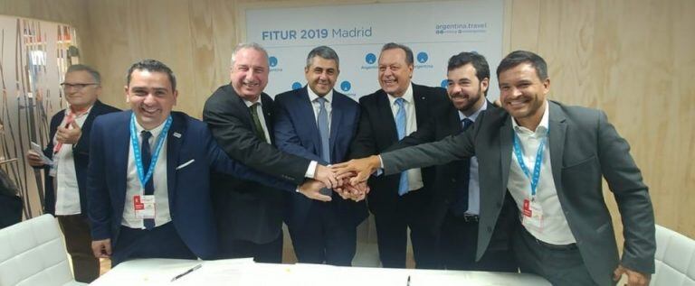 El ministro Posadas (derecha), el secretario Santos y el secretario general  de la OMT, Zurab Pololikashvili (ambos al centro), celebran la firma del convenio.