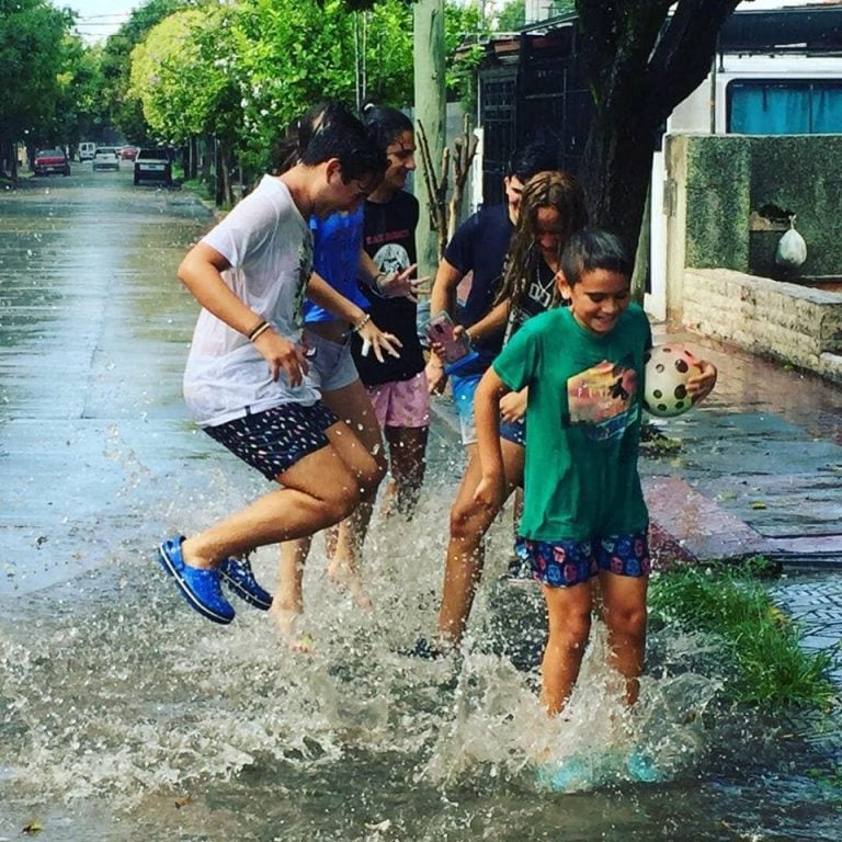 Las fotos de los adolescentes cordobeses jugando bajo la lluvia fueron tomadas por Juan Pablo Rodríguez, en barrio Los Naranjos.