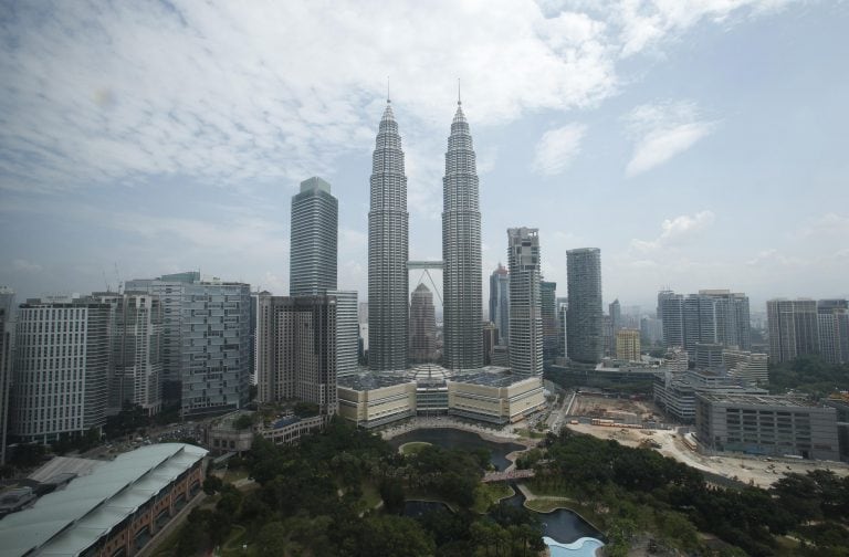 Los turistas posan para una foto frente a las Torres Petronas de Malasia, después que la bruma se disipa. (AP Photo/Lai Seng Sin)