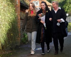 Women carry flowers to the house of singer George Michael, where he died on Christmas Day, in Goring, southern England, Britain December 26, 2016.  REUTERS/Eddie Keogh