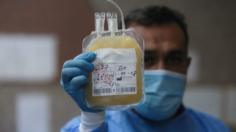 FILE PHOTO: A nurse wearing a protective face mask and gloves shows blood plasma from a person who has recovered from the coronavirus disease (COVID-19), to be used to help critically ill patients, at a blood bank in Basra, Iraq June 20, 2020. Picture taken 20, 2020. REUTERS/Essam Al-Sudani/File Photo