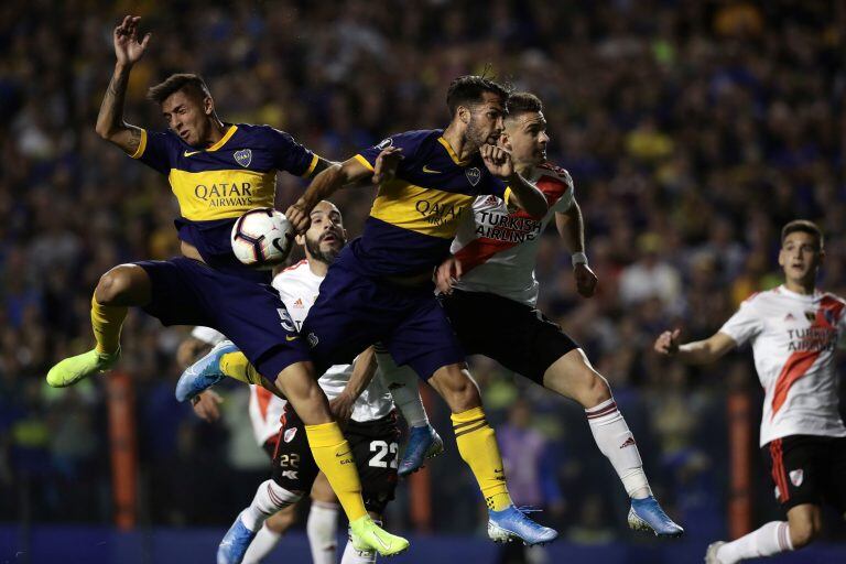 Players of Boca Juniors (Blue and yellow) and River Plate jump for the ball during their all-Argentine Copa Libertadores semi-final second leg football match at La Bombonera stadium in Buenos Aires, on October 22, 2019. (Photo by Alejandro PAGNI / AFP)