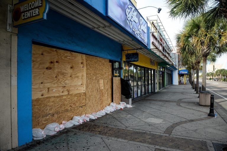 Negocios y casas con las ventanas cubiertas con planchas de madera. Foto: BLOOMBERG.