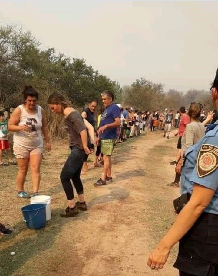 En Mina Clavero se formó un corredor humano de acarreo de agua para combatir los incendios. (Belen Intima)