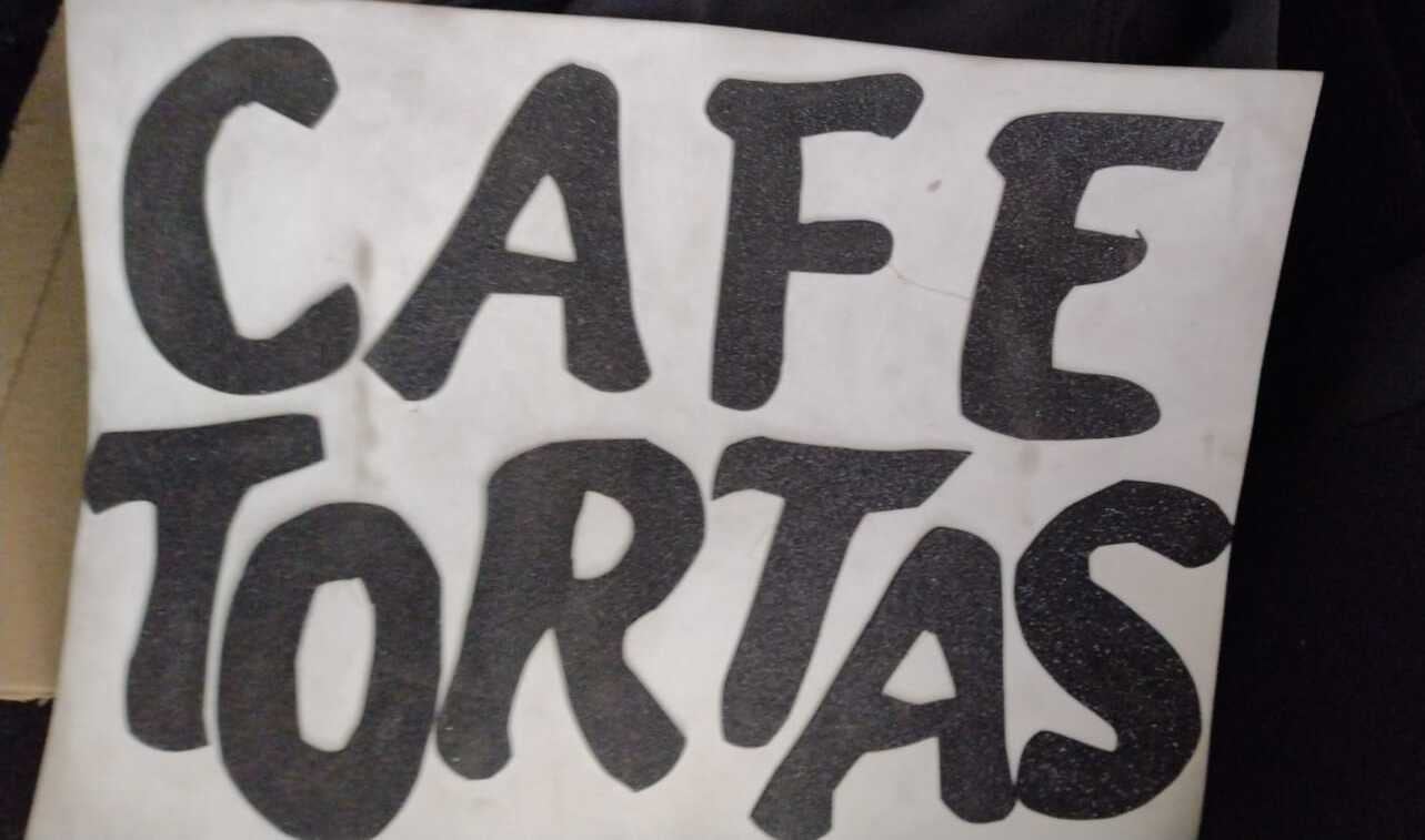 Este es el cartel que todos los días pone el vendedor para promocionar sus productos. El café que vende es amargo y se puede endulzar a gusto, afirma el vendedor.