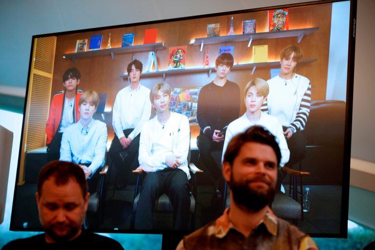 El artista danés Jakob Kudsk Steenson (d) durante la transmisión en vivo de la banda coreana BTS para hacer el anuncio de su nuevo trabajo "Catharsis" en el lanzamiento del proyecto de arte público global "Connect, BTS",  en Londres el 14 de enero de 2020. - El trabajo de Steenson presenta una simulación digital de un bosque antiguo reimaginado y es parte del proyecto de arte contemporáneo "Connect, BTS", que incluye a a 22 artistas en cinco ciudades en cuatro continentes. (Photo by ADRIAN DENNIS / AFP)