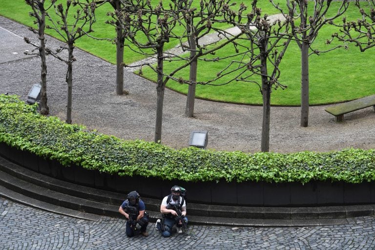 Armed police take cover outside the the Houses of Parliament, London, Wednesday, March 22, 2017.  London police say they are treating a gun and knife incident at Britain's Parliament "as a terrorist incident until we know otherwise." The Metropolitan Poli