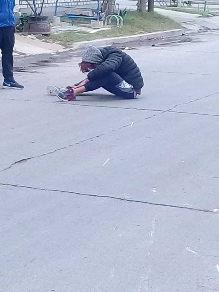 Lucero tendido en la carpeta asfáltica luego de caer de su moto.