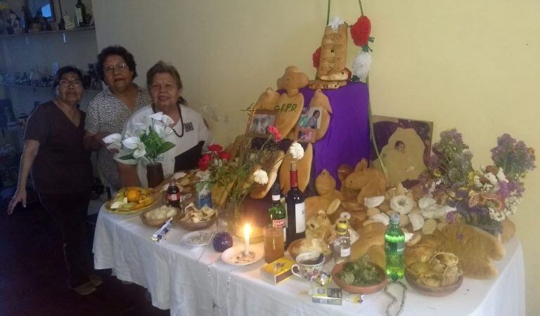 Las hermanas Luordes, Sara y Nora Zalazar, con el altar de la ofrendas.