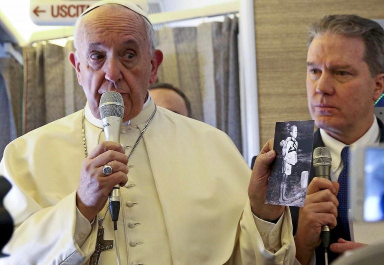 MXR01. CHILE 15/01/2018.- El papa Francisco sostiene una fotografía de una víctima de Nagasaki durante una charla con periodistas a bordo del vuelo hacia Chile hoy, 15 de enero de 2018. El papa Francisco emprendió hoy su viaje a Chile, desde donde el próximo día 18 se trasladará a Perú, en la que será una visita marcada por la defensa de las poblaciones indígenas y dará un mensaje de protección del medioambiente. EFE/ Alessandro Bianchi / Pool