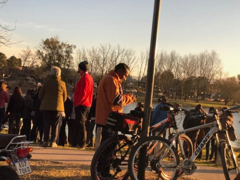 Vecinos presenciando el eclipse solar en la costanera de Carlos Paz