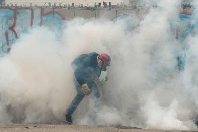 TOPSHOT - A demonstrator clashes with the riot police during a protest against Venezuelan President Nicolas Maduro, in Caracas on April 20, 2017.
Venezuelan riot police fired tear gas Thursday at groups of protesters seeking to oust President Nicolas Madu