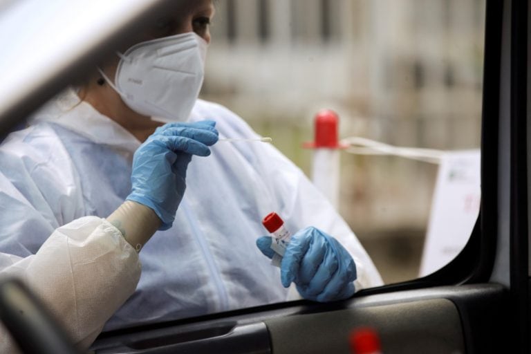 A medical worker wearing protective gear takes swabs to test for COVID-19 at a drive-through for people returning from Croatia, Spain, Malta and Greece, at the San Carlo hospital, in Milan, Italy, Tuesday, Aug. 25, 2020. People returning to Italy from Spain, Malta, Greece and Croatia must be tested within 48 hours of entering the country, after those nations saw worrisome upticks in infections. (AP Photo/Luca Bruno)