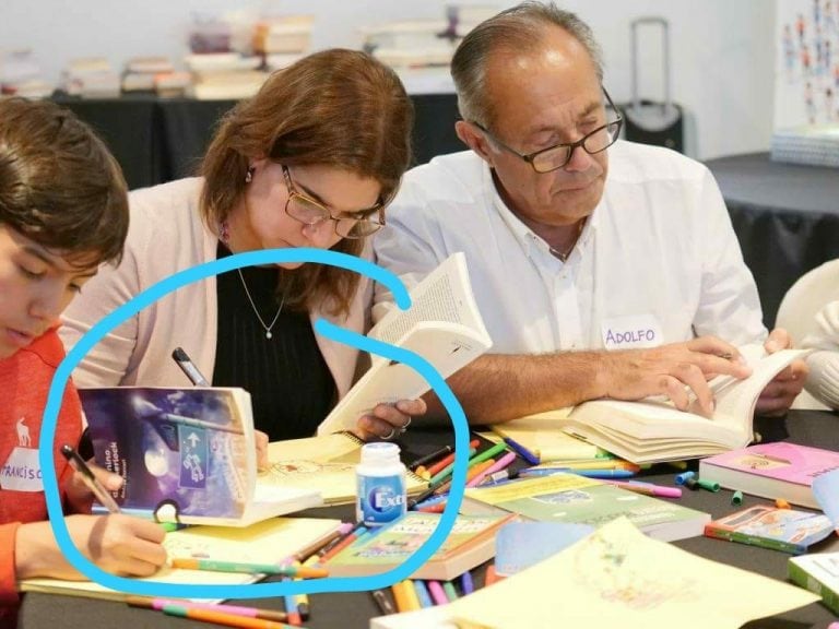 Adolfo y su familia leyendo libros al revés.