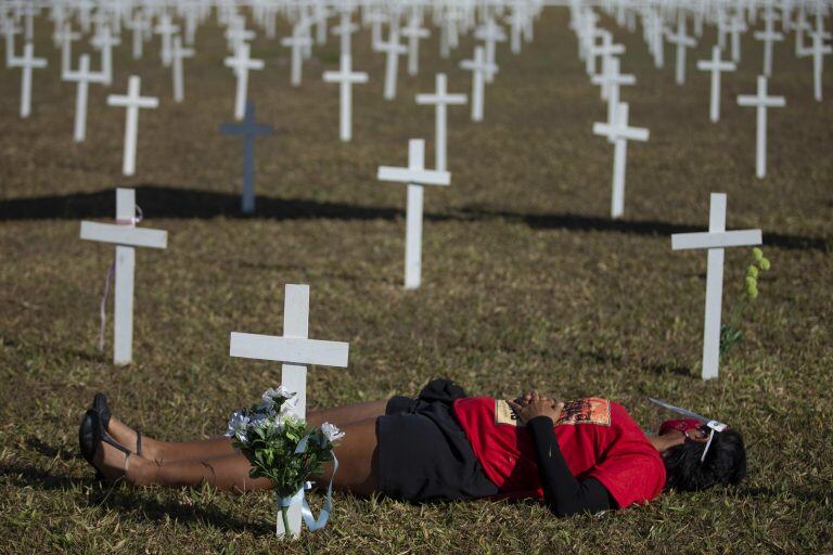 Varias personas participan en las instalación de centenares de cruces como homenaje a las víctimas de Covid-19 en la Explanada de los Ministerios de Brasil (Foto: EFE/ Myke Sena)