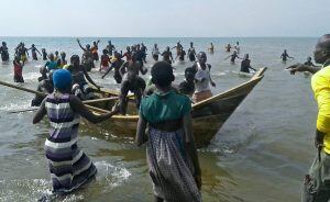 Survivors of a boat accident come back ashore on Lake Albert, on December 26, 2016 in Buliisa, after at least 30 Ugandan members of a village football team and their fans drowned when their boat capsized on Lake Albert during a party.
Police officers work