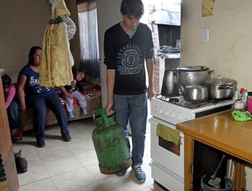 Cecilia Ortega junto a sus hijas y su esposo ayudando en la cocina.