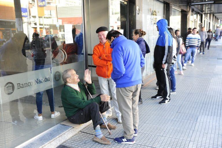 Extensas filas en los bancos porteños y del Conurbano para cobrar jubilaciones y planes sociales. (Clarín)