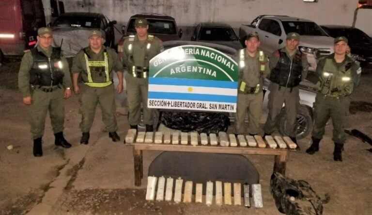 El personal a cargo del operativo exhibe los paquetes de droga hallados en el auto.