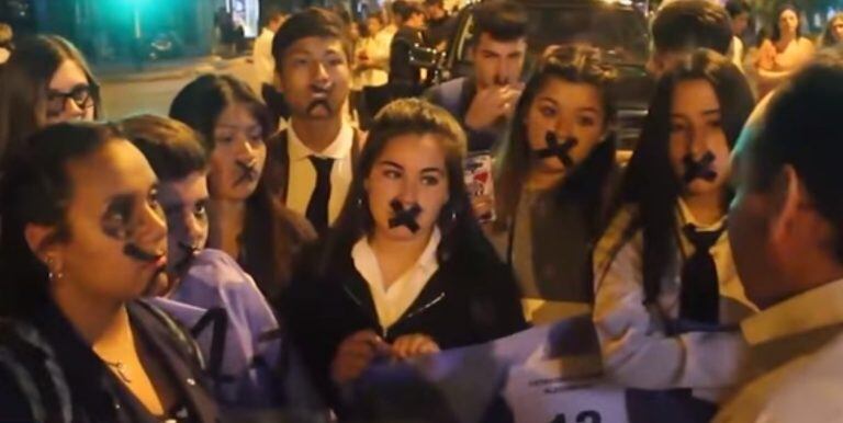 Los alumnos decidieron intervenir el desfile bajo la consigna "los lápices siguen escribiendo". Se taparon la boca con una cinta en forma de cruz y caminaron con la bandera de su colegio.