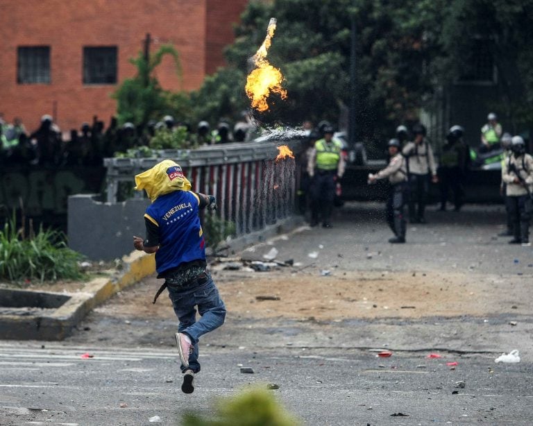 -FOTODELDIA- CAR19. CARACAS (VENEZUELA), 20/04/2017.- Manifestantes se enfrentan con agentes de la Policía Nacional Bolivariana (PNB) hoy, jueves 20 de abril de 2017, en Caracas (Venezuela). Grupos de centenares de opositores al Gobierno venezolano se enf