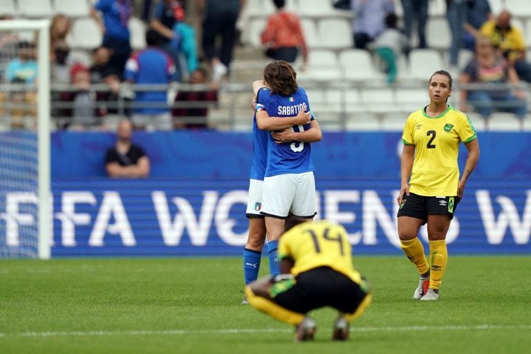 El abrazo de dos jugadoras Italianas, adentro de octavos, ante una jamaiquina, prácticamente eliminada (Foto: Lionel BONAVENTURE / AFP)