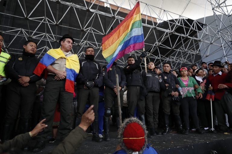 Policías retenidos se forman frente a varios indígenas este jueves en la Casa de la Cultura de Quito. (EFE)