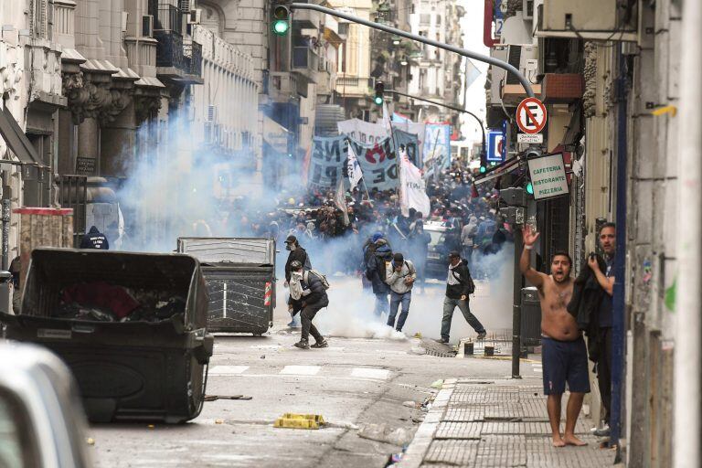 Manifestantes encapuchados arrojan piedras, palos y elementos pirotécnicos en rechazo a la aprobación de la Ley de Presupuesto 2019 (EFE/Luis Alberto Pozzi)