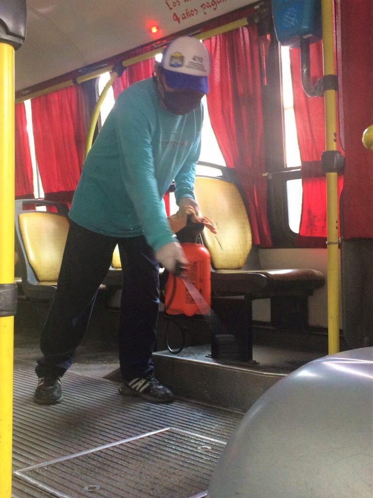 Un operario realiza la desinfección de un colectivo, previo a reiniciar su recorrido en San Salvador de Jujuy.